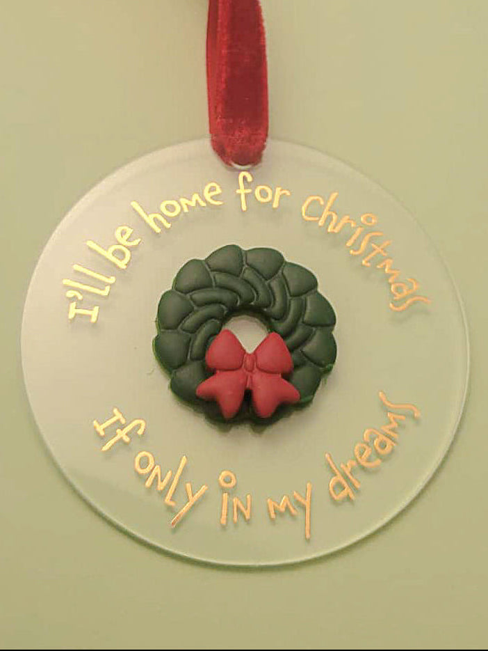 Round Christmas ornament with wreath and text on a green background