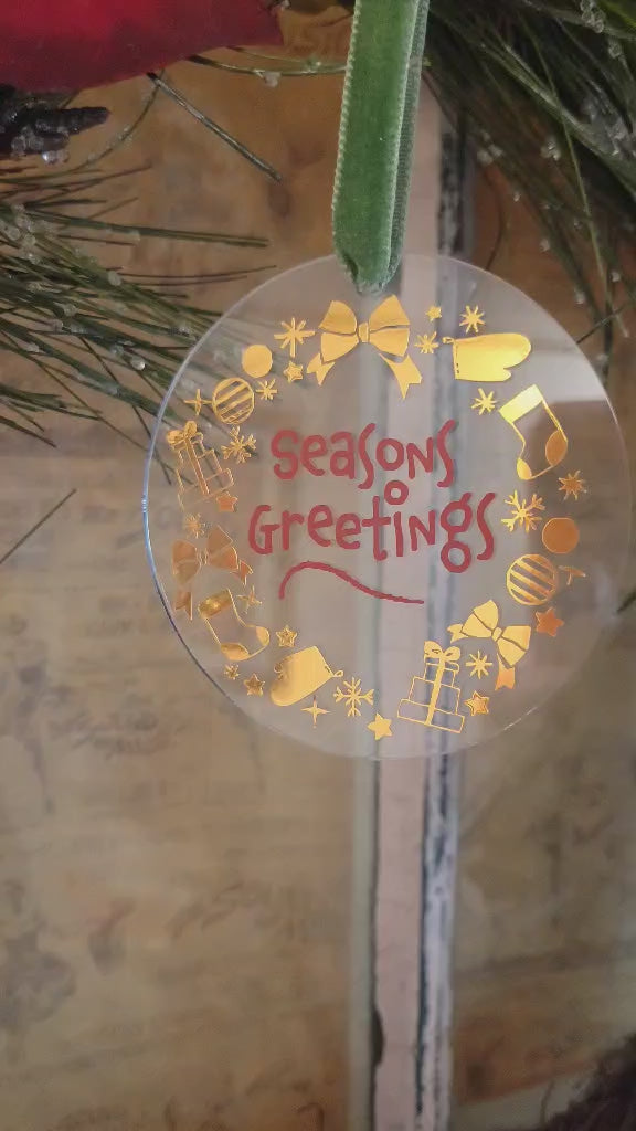 Video showing the lighting on a clear acrylic round ornament with gold and red vinyl hanging on a wreath